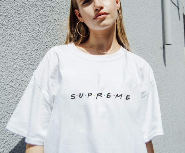 T-shirt bianca di Fornever con logo "Supreme" in stile serie TV Friends. La logomania e la tendenza alla caricatura: vediamo il caso DEISEL a Canal Street, New York e altre celebri caricature e falsi del mondo della moda!